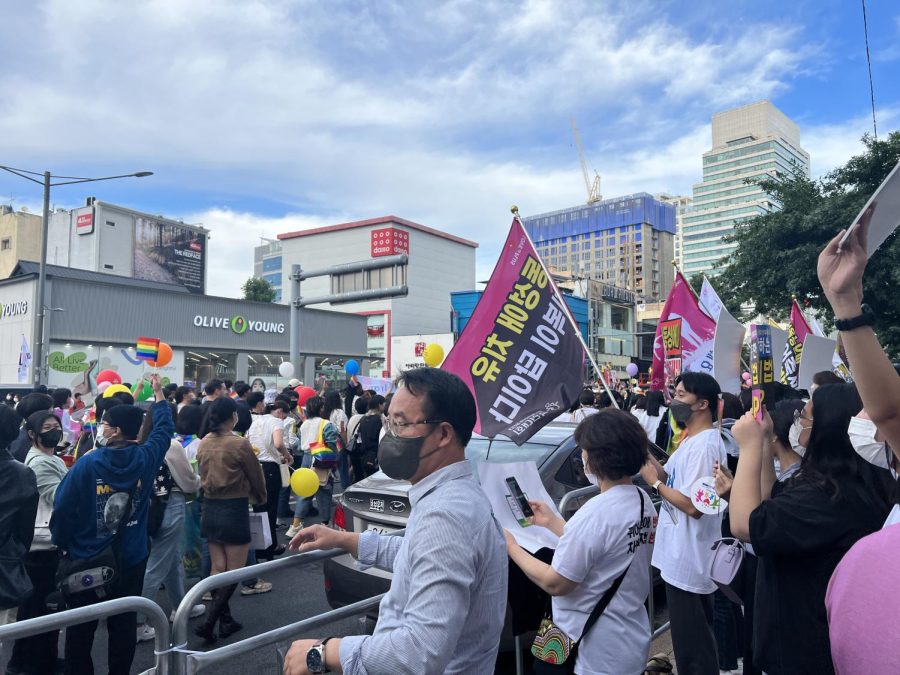 The anti-queer protesters hold their placards on the sidelines as the pride parade marches by, one of which roughly translates to, “Conversion is the answer.