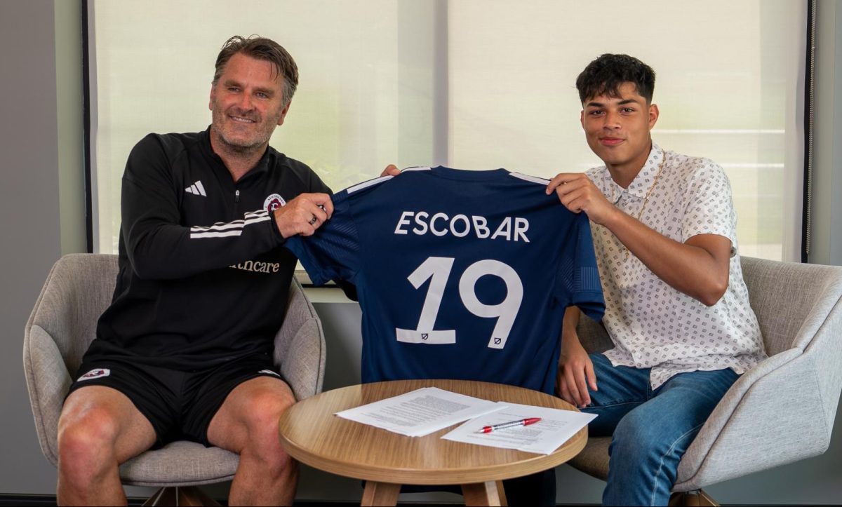 Olger Escobar (right) holds up his new New England Revolution jersey along with Curt Onalfo, the teams technical director, after signing his pro contract July 26, 2023.