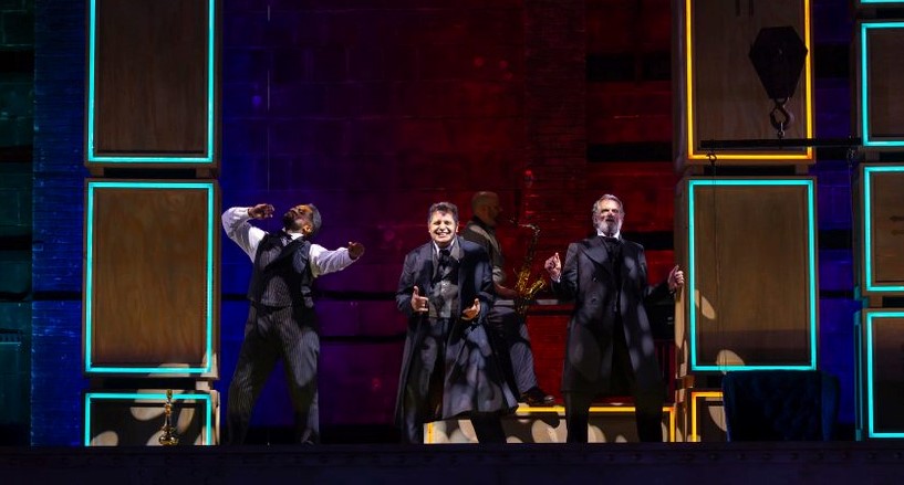 Joshua David Robinson, Firdous Bamji, Steven Skybell (left to right) play more than 50 roles in The Lehman Trilogy at Huntington Theatre in Boston, while musician Joe LaRocca (background) is also deserving of his own spotlight.