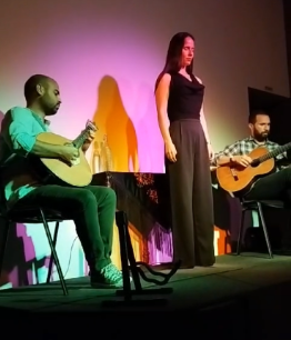 Ana Margarida (standing) taking a moment before singing a Fado classic with Pedro Martins (left) playing the Portuguese guitar and Yuri Reis playing the standard guitar.