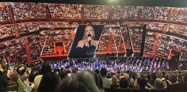 Adele performing in front of a giant video screen and in front of a packed house during her residency at The Colosseum in Las Vegas on Aug. 5, 2023. 
