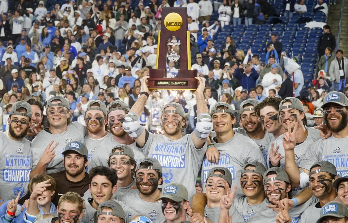 The Tufts men's lacrosse team poses with the NCAA Division 3 trophy after a 25-8 victory over Dickinson in the title game at Gillette Stadium on May 25, 2025.