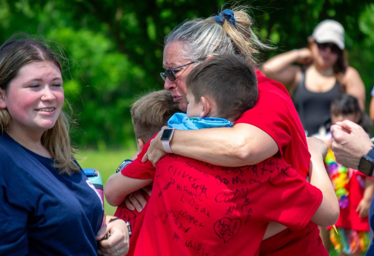 Ashby Elementary principal Anne Cromwell-Gapp hugs two students through tears on what have been the school's last day on June 12, 2025..