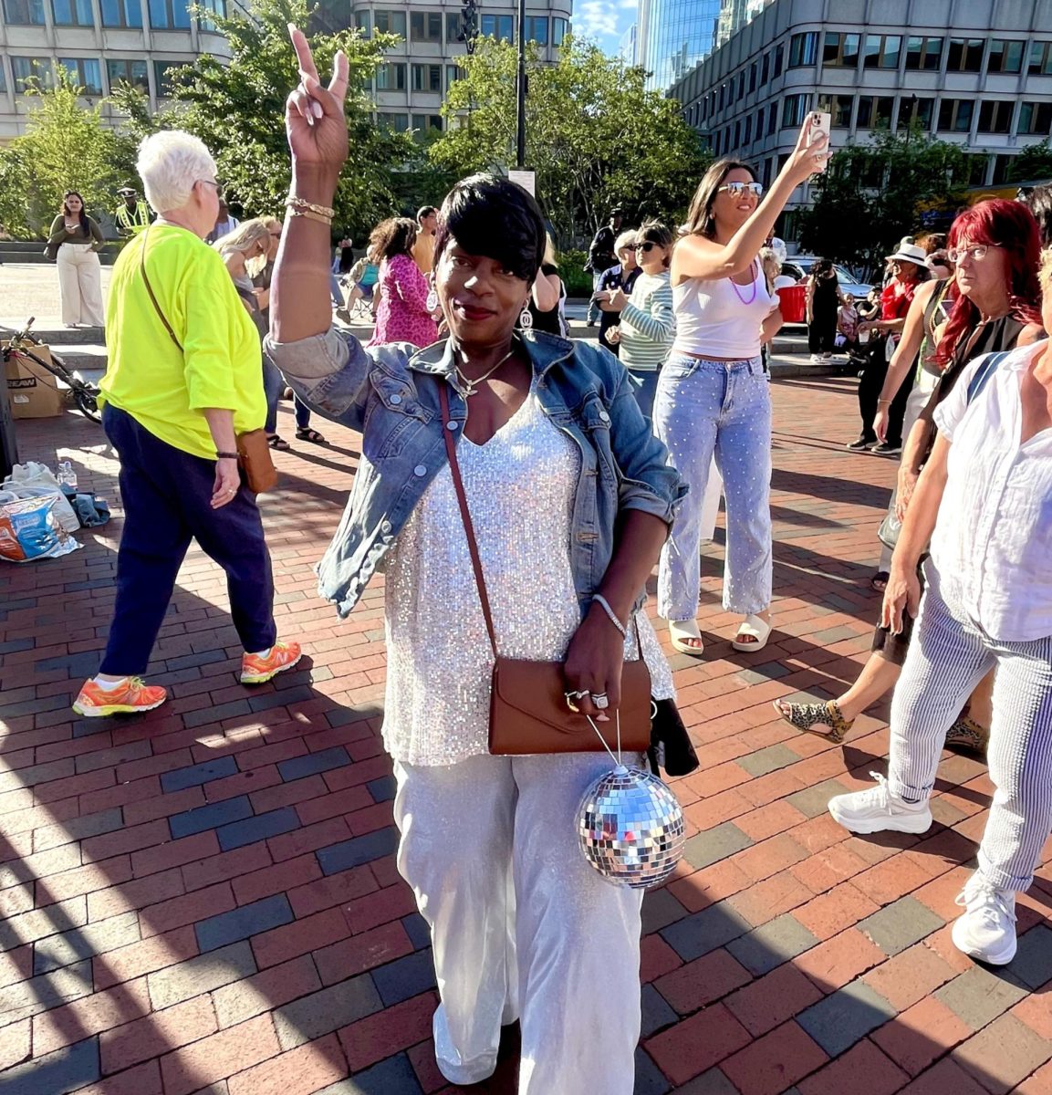 Tarisa, a Boston native, is dressed to the nines and accompanied by a mini disco ball clutch, at Boston's City Hall Plaza for the pre-Donna Summer Roller Disco Party on June 27, 2025.