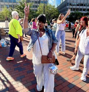 Tarisa, a Boston native, is dressed to the nines and accompanied by a mini disco ball clutch, at Boston's City Hall Plaza for the pre-Donna Summer Roller Disco Party on June 27, 2025.